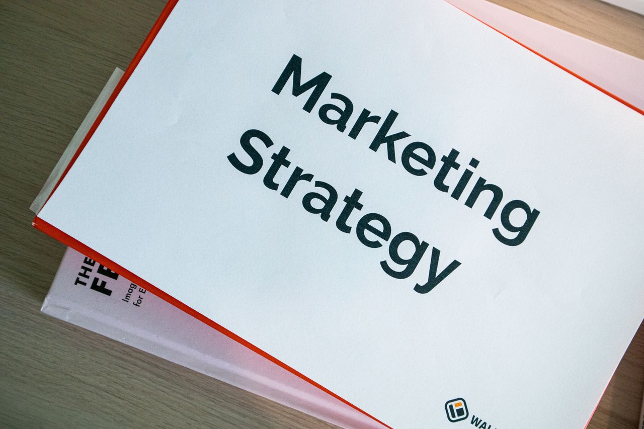 about-us A marketing strategy document displayed on a desk, showcasing business planning essentials.